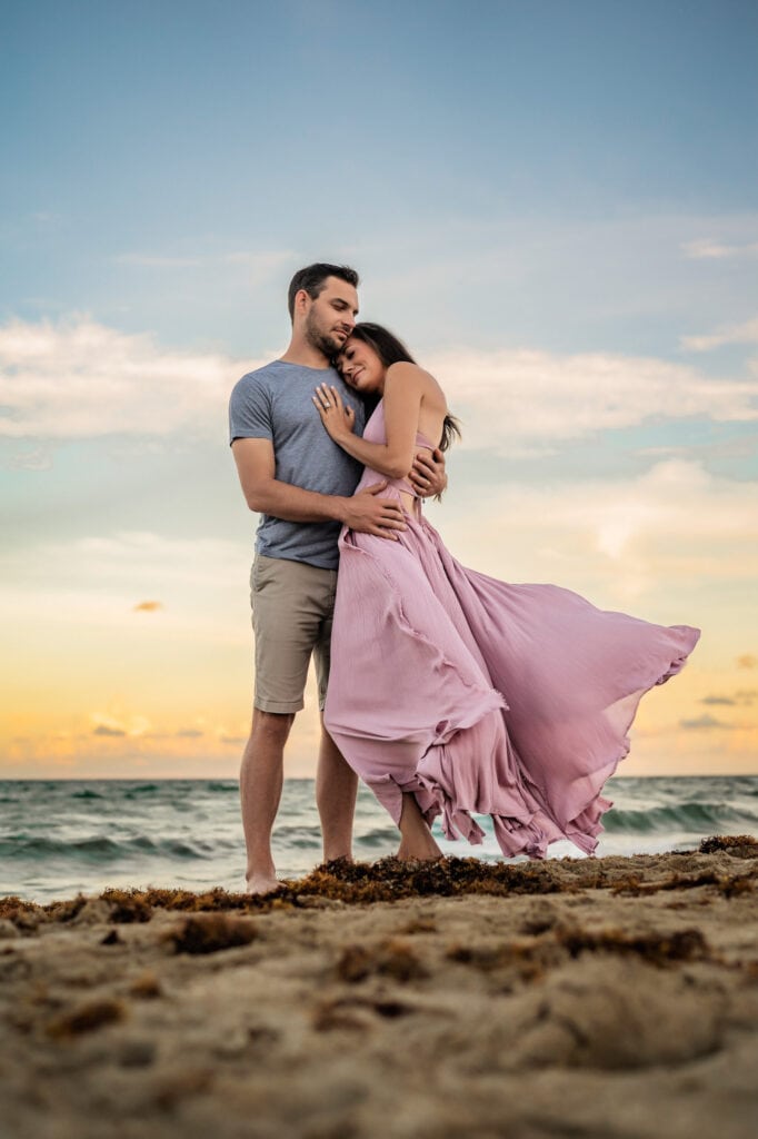 Family Photographer, a man and woman embrace near the tides at the beach
